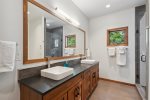 Featuring 2 sinks and a glass and tile shower.
